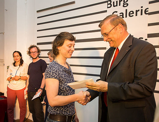 Jan-Hinrich Suhr, Mitglied des Vorstands der Stiftung der Saalesparkasse, gratuliert der Preisträgerin Anne Baumann. Foto: Matthias Ritzmann