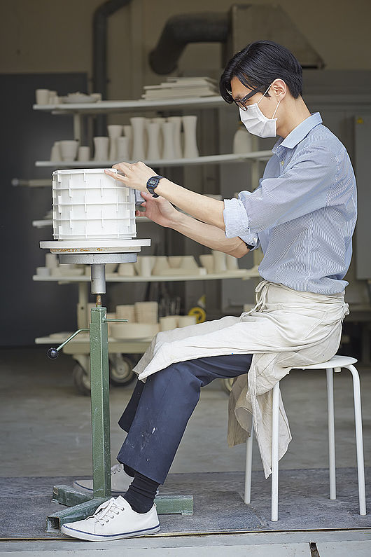 Kyungmin Lee verputzt den ungeschrühten Porzellankörper zur Vorbereitung auf den Schrühbrandes bei 900°C, Foto Marco Warmuth