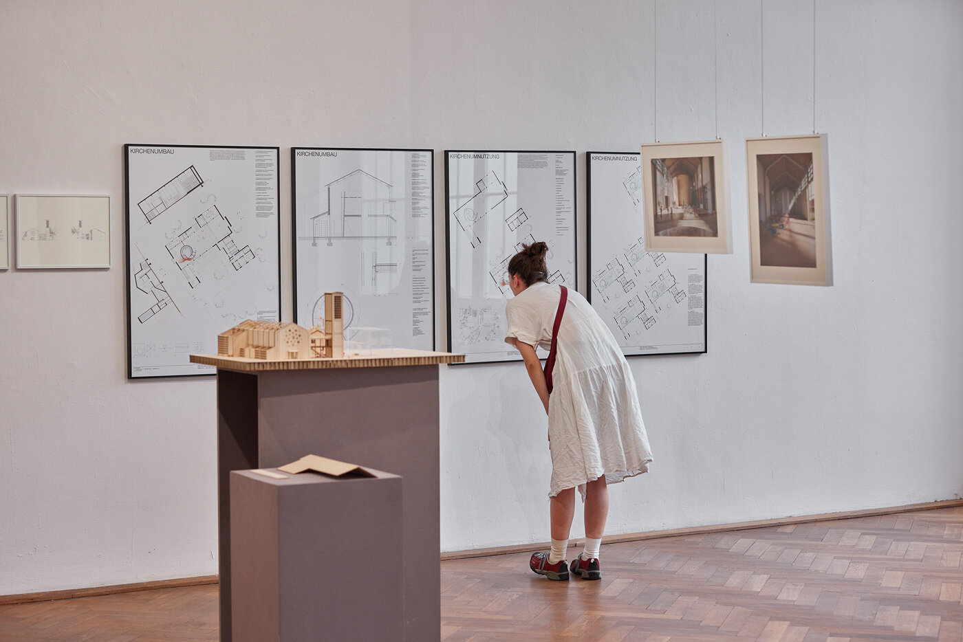 Foto einer Person die das Modell und die Pläne studiert