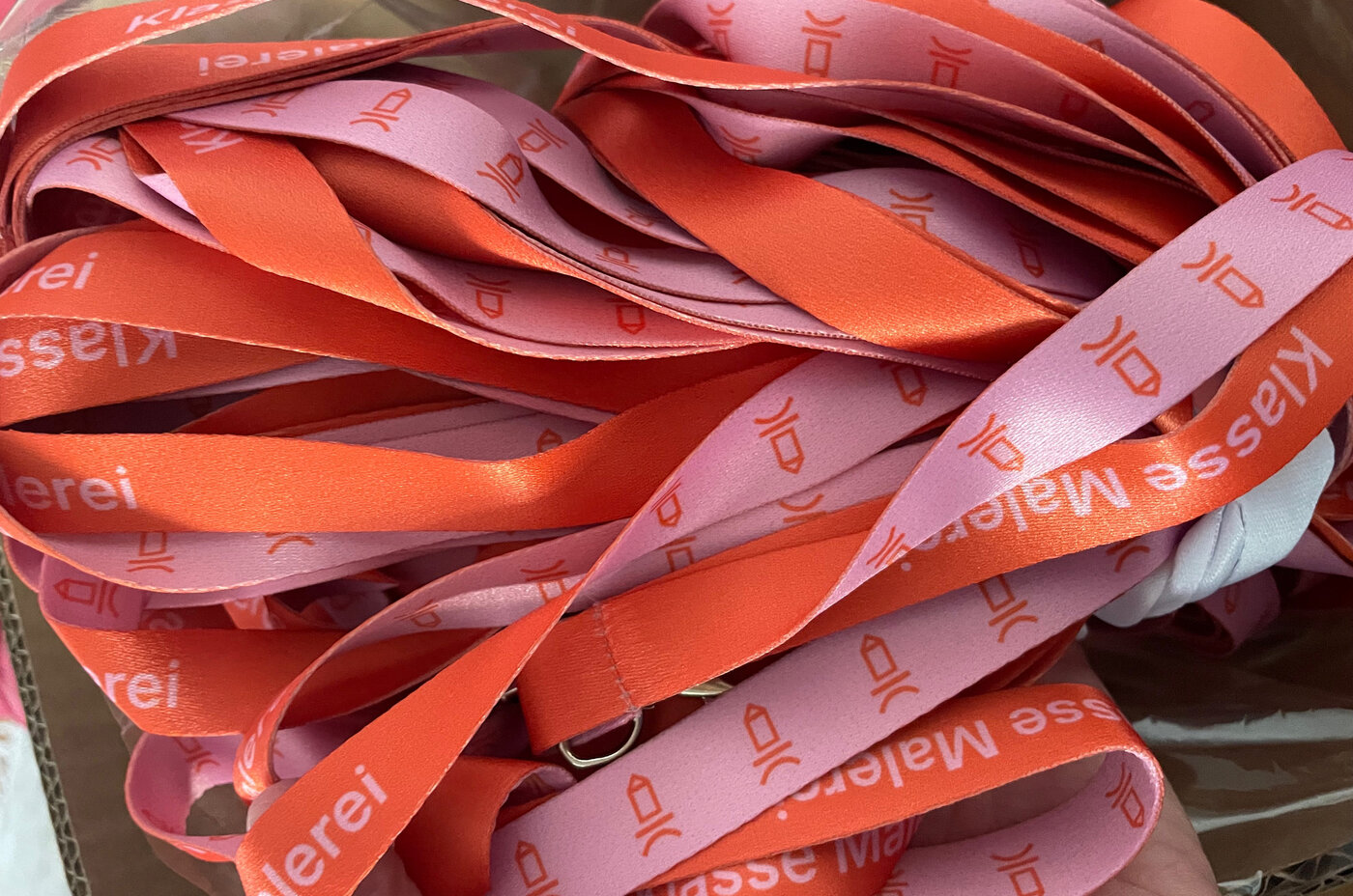 Schlüsselanhänger in orange/pink mit der Aufschrift 'Malereiklasse'
