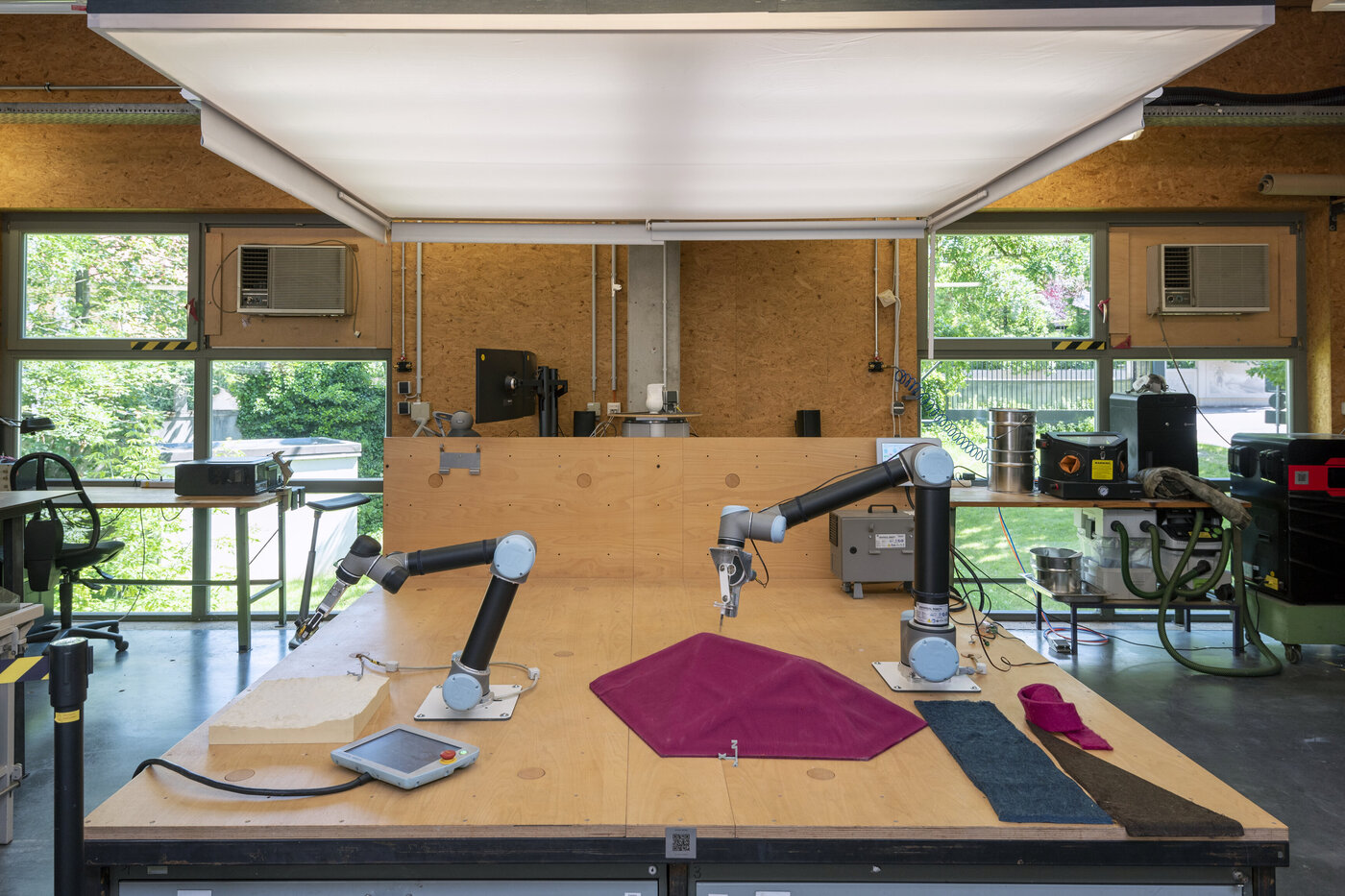 Übersichtsaufnahme der XLab RoboStage in der Digitalen Werkstatt mit zwei Roboterarmen und Materialproben - Foto Sven Bergelt