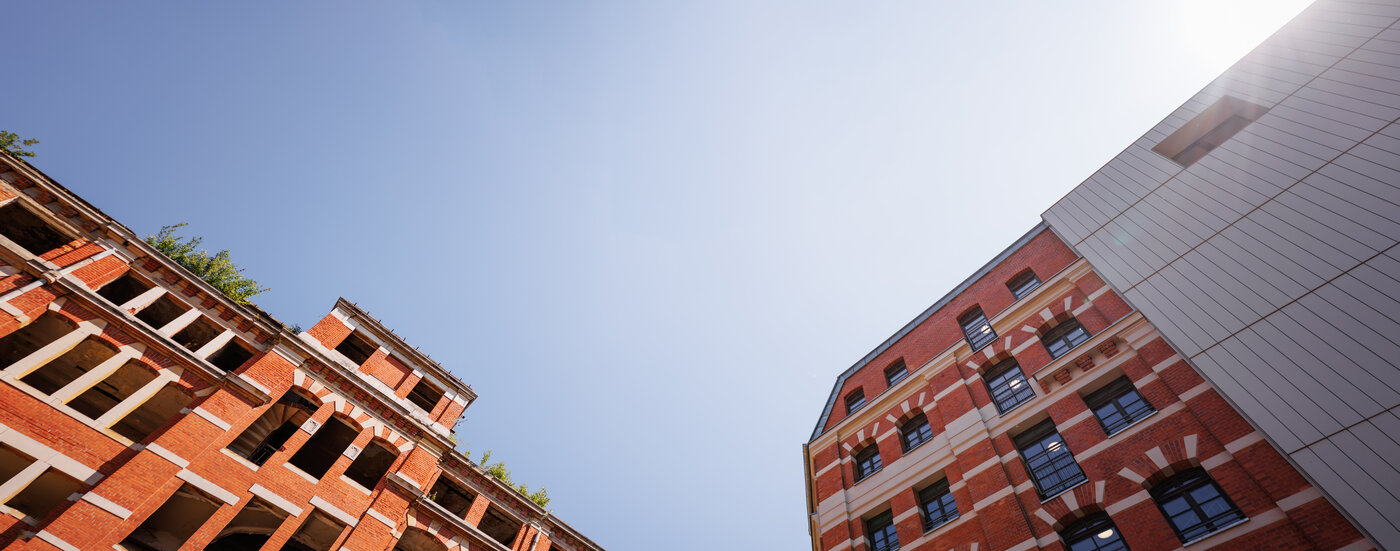 Farbfotografie zweier Gebäudeteile aus extremer Perspektive von unten