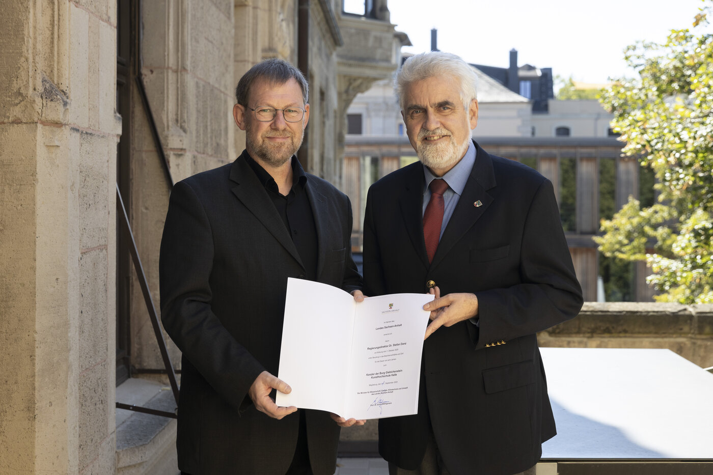 Minister Prof. Dr. Willingmann überreicht Dr. Stefan Danz die Ernennungsurkunde zum neuen Kanzler der BURG
