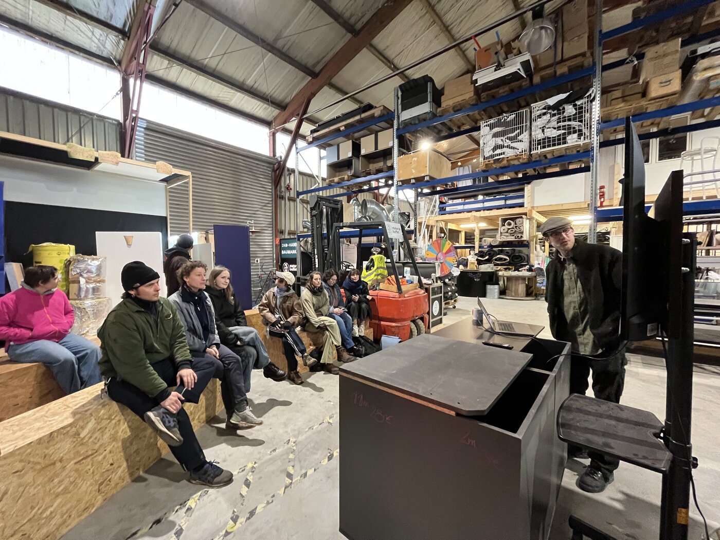 Exkursion Materialbuffet Leipzig StudiengrupStudiengruppe hört Vortrag im Materialbuffet Leipzig während einer Exkursionpe lauscht Vortrag