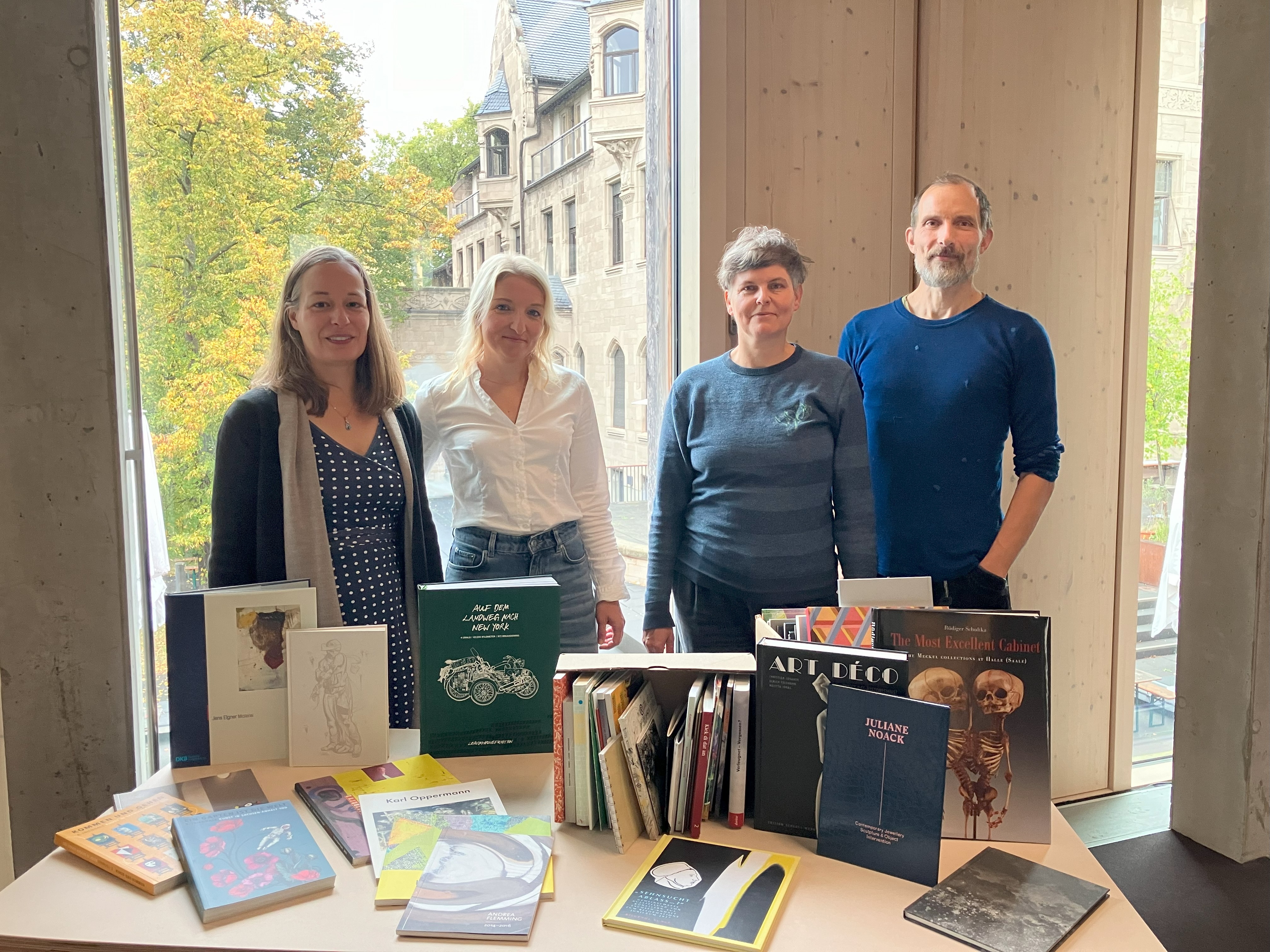 Erste Übergabe von Büchern am 8. Oktober 2025 in der Bibliothek der Burg Giebichenstein Kunsthochschule Halle. V.l.n.r.: Anne-Kathrin Bernsdorf und Katharina Loos (Burg-Bibliothek) sowie Ruth Heftrig und René Schäffer (BBK).
