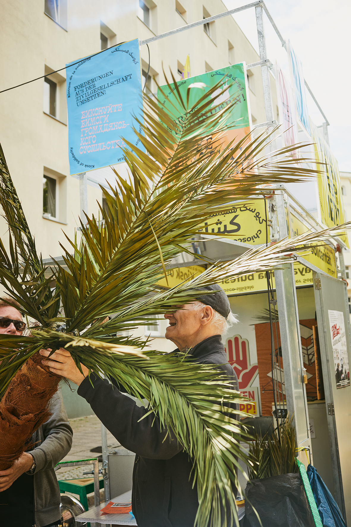 Der Aufbau des Kiosks im Juli 2023 in der Habersaathstraße. Dort stand er inzwischen schon zweimal. Die Habersaathstraße 40–48 wurde 1984 als Wohnheim für Mitarbeiter*innen der Charité gebaut und 2006 vom Senat an einen privaten Investor verkauft. Nach einem erneuten Verkauf beantragte die neue Eigentümerinnengesellschaft 2018 den Abriss, woraufhin Instandsetzungen ausblieben, das Haus teilentmietet wurde und während des Winters 2021/22 leerstehende Wohnungen von wohnungslosen Menschen und später von Geflüchteten aus der Ukraine besetzt wurden – Bewohner*innen, die bis heute aufgrund solidarischer Unterstützung und öffentlicher Aufmerksamkeit geduldet sind. Die Initiative Habersaathstraße kämpft solidarisch gegen den Abriss und Entmietung ihres Hauses. Sie ist wichtiger Teil des Kiosk-Netzwerkes. Foto © Monika Keiler
