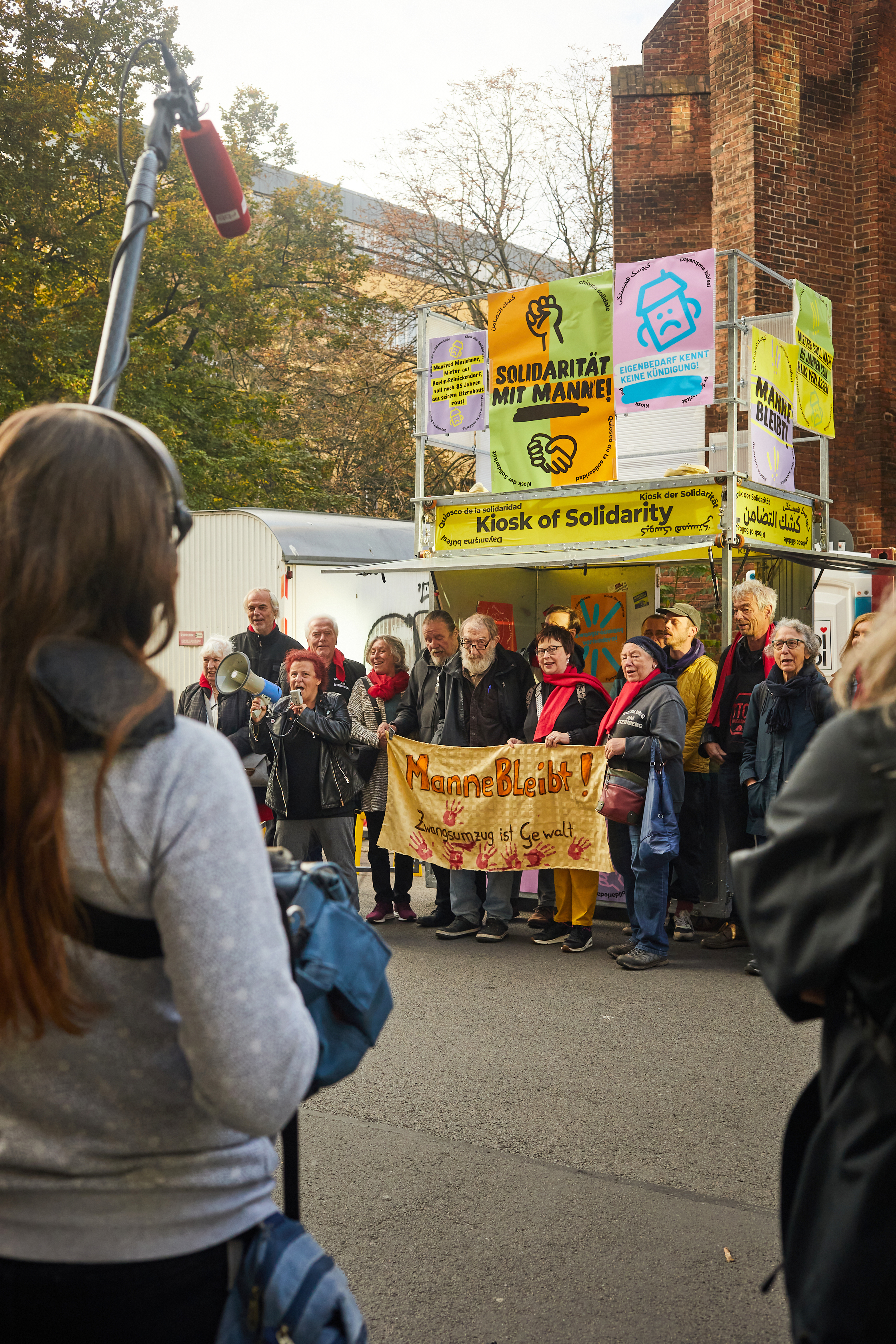Das „Bündnis gemeinsam gegen Obdachlosigkeit und Zwangsräumungen“ bei einer Soli-Aktion vor einem Gerichtsverfahren gegen den 85-Jährigen Mann vor dem Amtsgericht in Berlin-Mitte. Dieser sollte sein Haus in Berlin-Reinickendorf, in dem er geboren wurde, verlassen. Das Bündnis setzt sich für die Rechte von obdachlosen und von Zwangsräumung bedrohten Menschen ein, indem es gegen die Verdrängung und für solidarische Lösungen kämpft. Es verbindet verschiedene Initiativen und engagiert sich für eine gerechte Wohnpolitik sowie die direkte Unterstützung von Betroffenen in Form von Aufklärung, Widerstand und politischem Druck. Das Bündnis hat den Kiosk schon an drei unterschiedlichen Orten in Berlin-Mitte bespielt. Foto © Monika Keiler